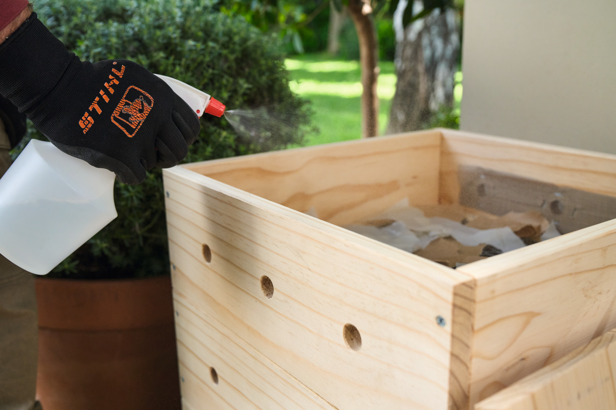 Une personne humidifie les restes de papier avec un pulvérisateur d’eau